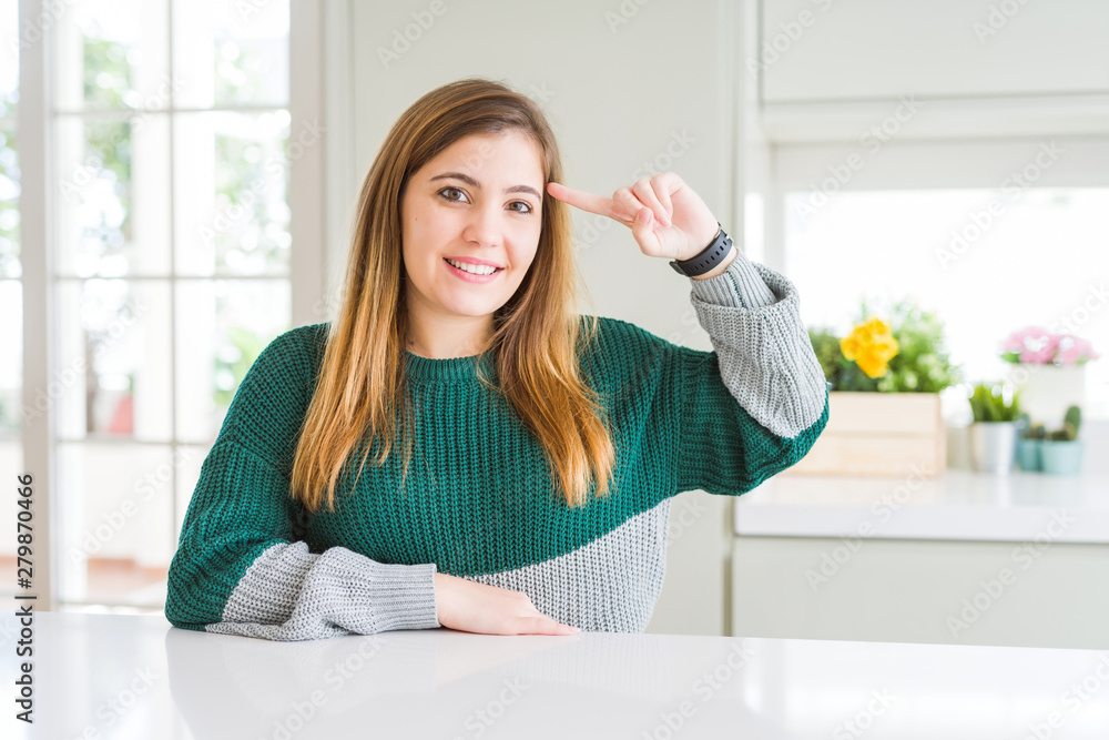 Young beautiful plus size woman wearing casual striped sweater Smiling pointing to head with one finger, great idea or thought, good memory Young beautiful plus size woman wearing casual striped sweater Smiling pointing to head with one finger, great idea or thought, good memory