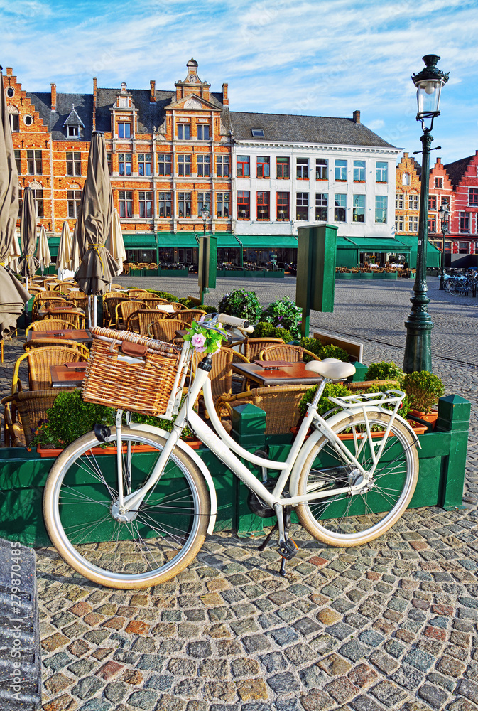 Fototapeta premium Bicycle parking near traditional street cafe on Grote Markt square in medieval city Brugge at morning, Belgium.