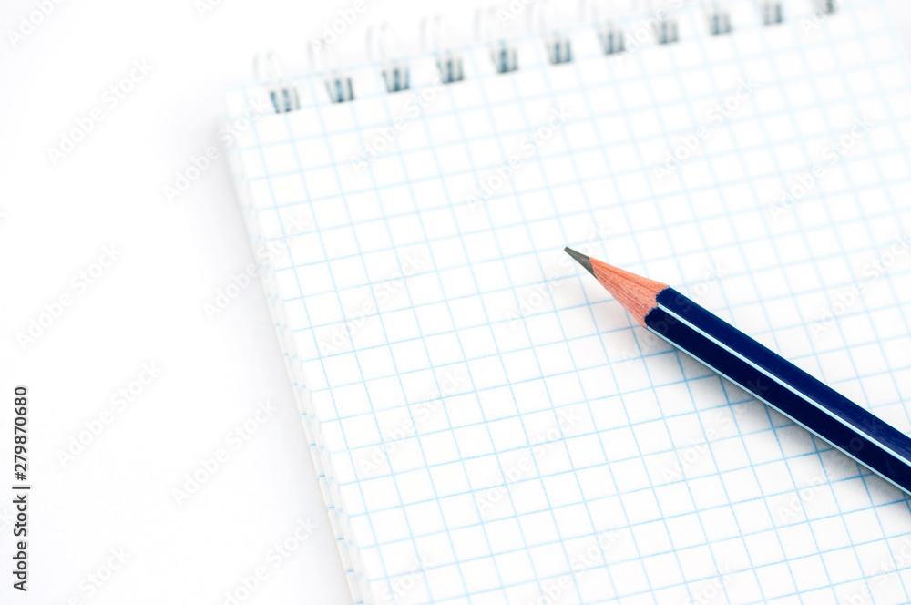 a simple pencil on a checkered notebook a simple pencil on a checkered notebook