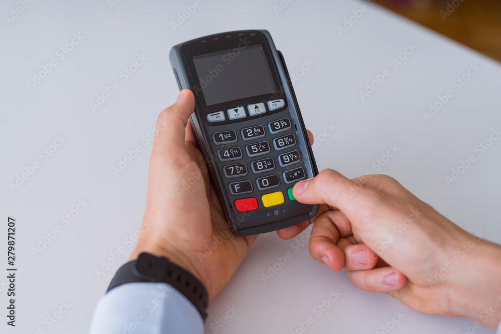 Close up of man hands holding pos terminal Close up of man hands holding pos terminal