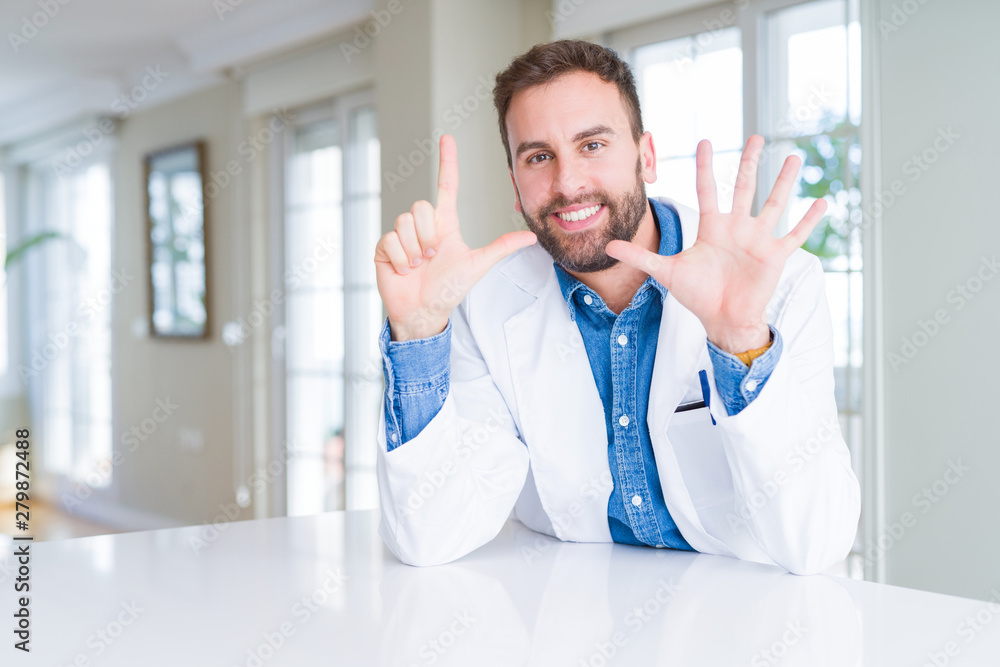 Handsome doctor man wearing medical coat at the clinic showing and pointing up with fingers number seven while smiling confident and happy.