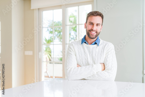 Handsome man wearing casual sweater happy face smiling with crossed arms looking at the camera. Positive person.