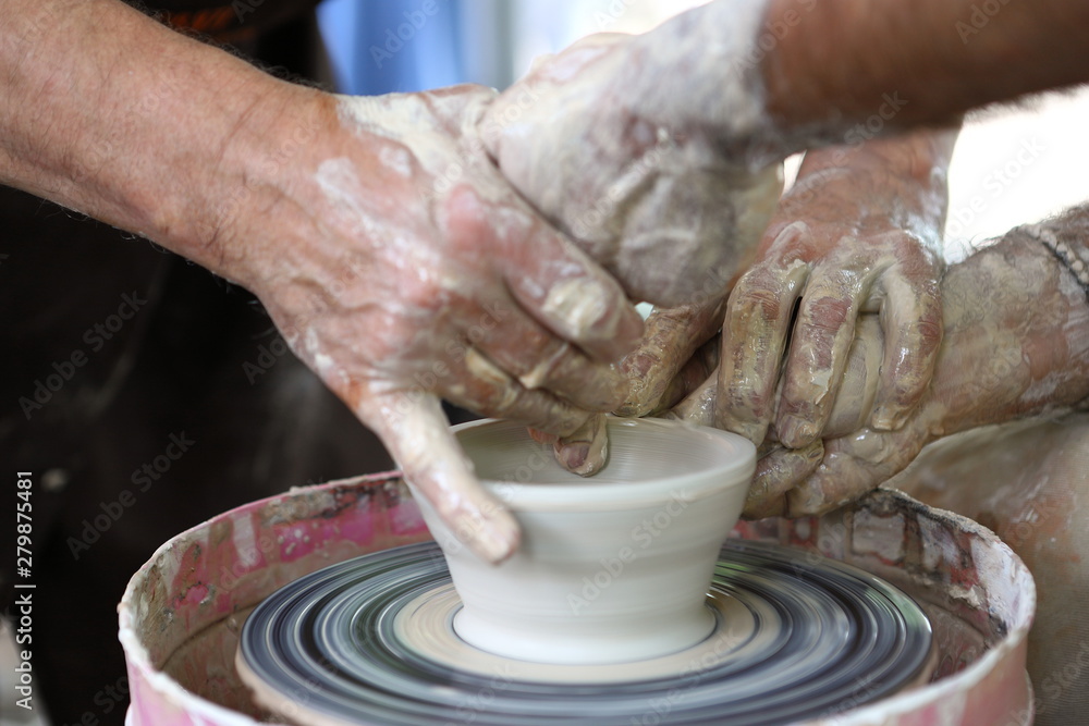 Master of ceramics. We work with clay. The master ceramist teaches the student. Craftsman hands sculpts clay