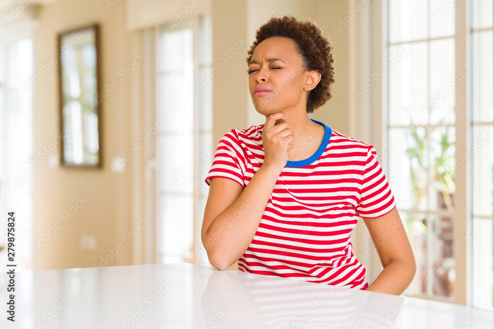 Young beautiful african american woman at home Touching painful neck, sore throat for flu, clod and infection Young beautiful african american woman at home Touching painful neck, sore throat for flu, clod and infection