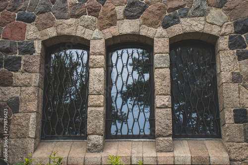 three vintage Windows in a stone wall