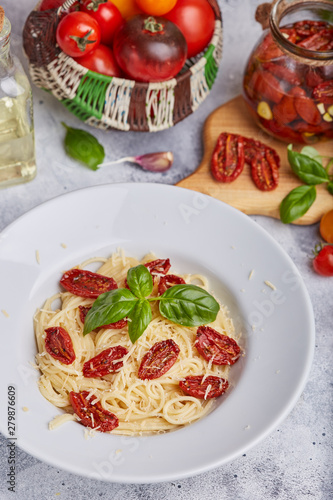 Spaghetti pasta with sun dried tomatoes, basil leaf and parmesan cheese. Vegetarian food. 