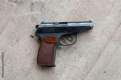 Metal gun on a gray concrete background. top view, flat lay, copy space photo