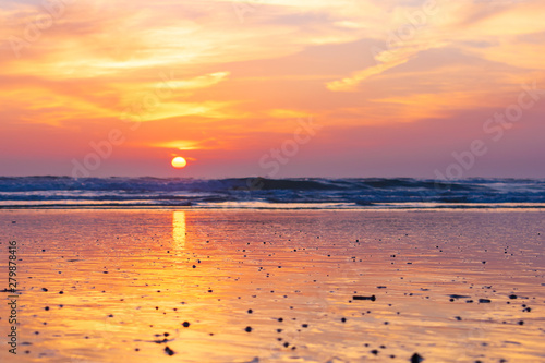 Colorful sunset sky with reflection on the beach along with wave in the ocean at Oceanside, California, USA.
