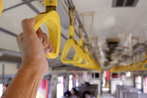 Focus on traveler man's hand holding handle on the train, transportation and travelling by train concept 