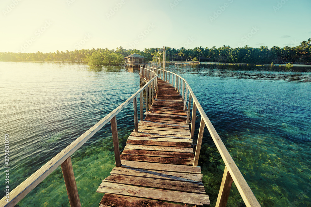Naklejka premium Beautiful landscape. Sunset on the seashore. Wooden bridge on the beach, Siargao Island, Philippines.