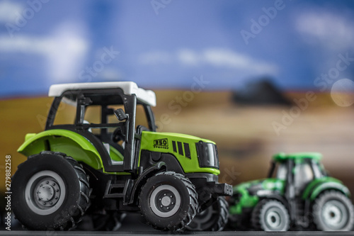 Two children's tractors on a blurred background of the field