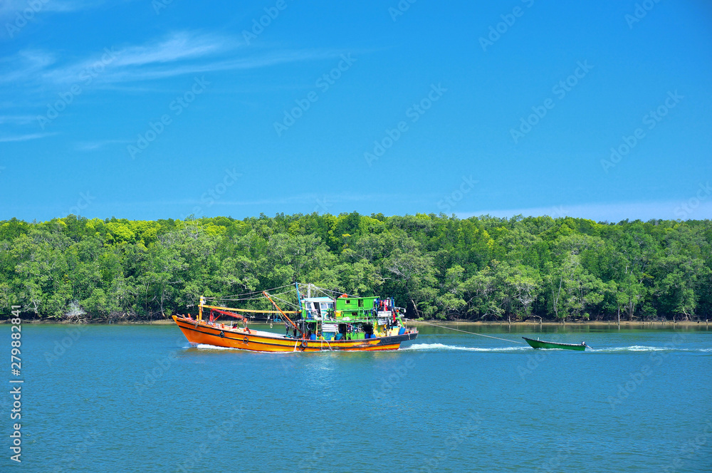 Fototapeta premium An old, rusty fishing trawler returning to harbor