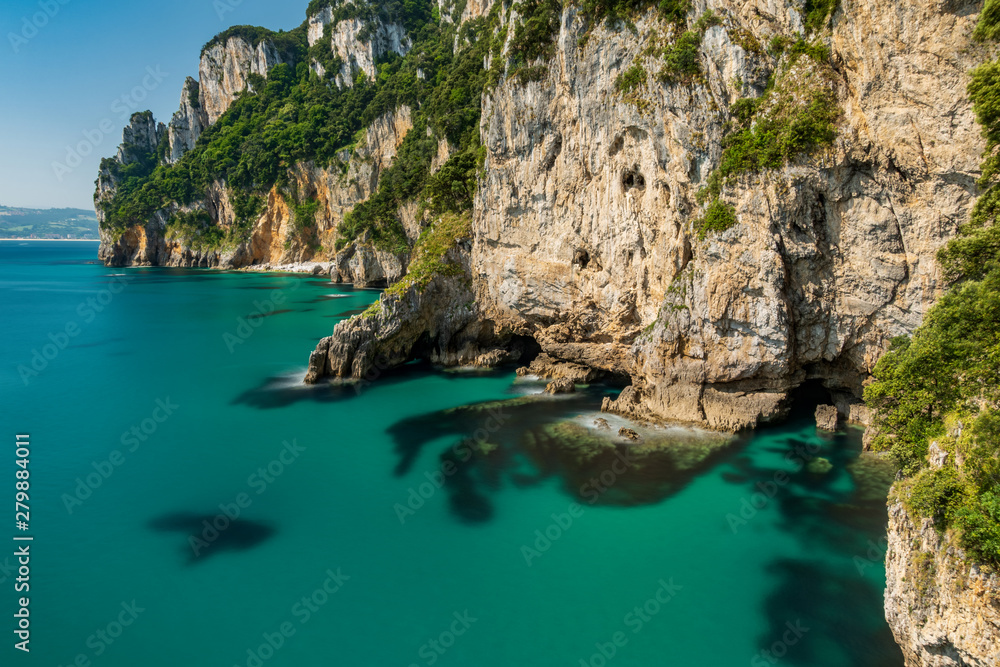 Long exposure of coastline with cliffs and bright clear water