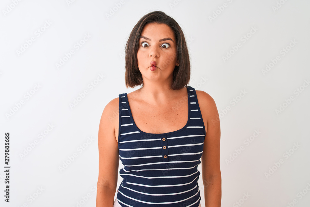 Young beautiful woman wearing blue striped t-shirt standing over isolated white background making fish face with lips, crazy and comical gesture. Funny expression. Young beautiful woman wearing blue striped t-shirt standing over isolated white background making fish face with lips, crazy and comical gesture. Funny expression.