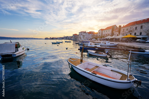 Beautiful sunset landscape. Fishing boat moored on Kastel coast in Dalmatia,Croatia.Old town near Adriatic sea.
