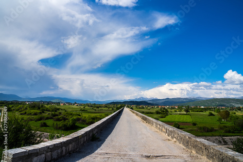 Montenegro, On ancient bolt upright emperors bridge building with endless road and view over beautiful mountains and nature landscape of niksic village