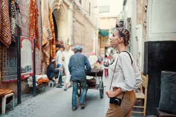 Tourism and technology. Happy young woman taking photo of  Marrakesh old town. Traveling by Morocco.