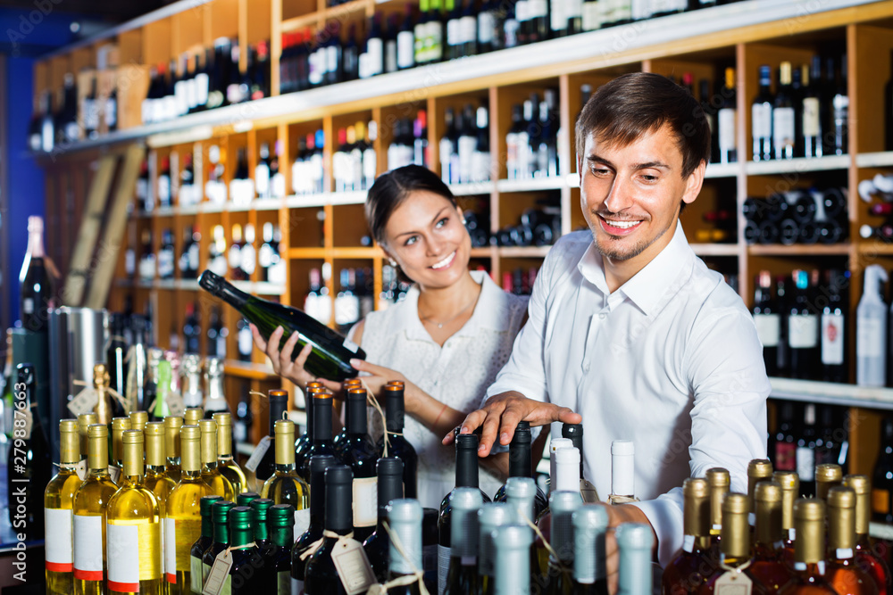 Portrait of  male and female customers picking bottle of wine