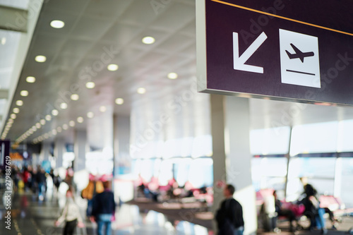 Sign in terminal with an arrow showing direction. Interior of the airport. © luengo_ua
