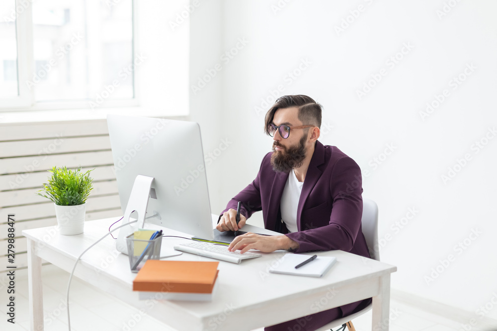 People and technology concept - Attractive man with beard, dressed in purple jacket working on at the computer