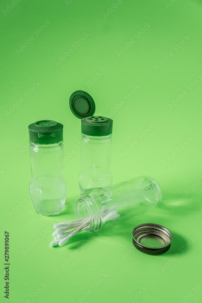 3 Empty glass spice jars on lime green background with blank empty room space 3 Empty glass spice jars on lime green background with blank empty room space