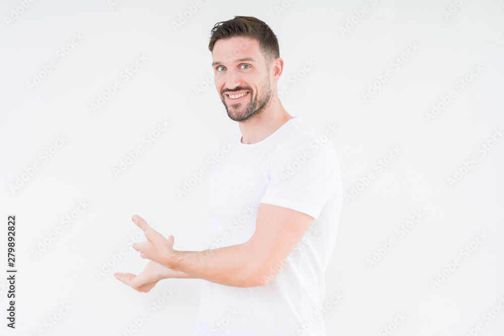 Young handsome man wearing casual white t-shirt over isolated background Inviting to enter smiling natural with open hand Young handsome man wearing casual white t-shirt over isolated background Inviting to enter smiling natural with open hand