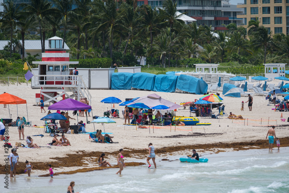 Summer scene Miami Beach. Crowded sand and lifeguard tower