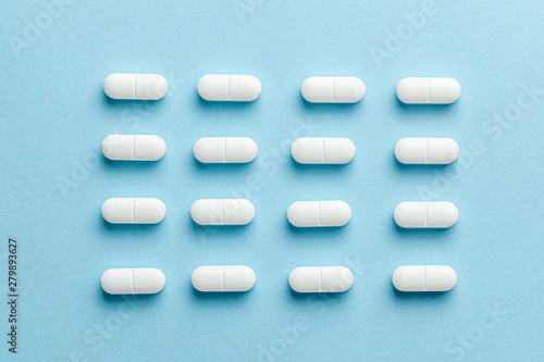 White pills on blue background.