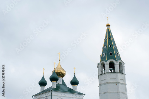 Church domes and a high bell tower against a cloudy sky. photo