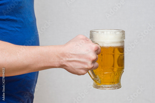 Hand hold glass mug of beer on white background. Beer in a glass holding by hand