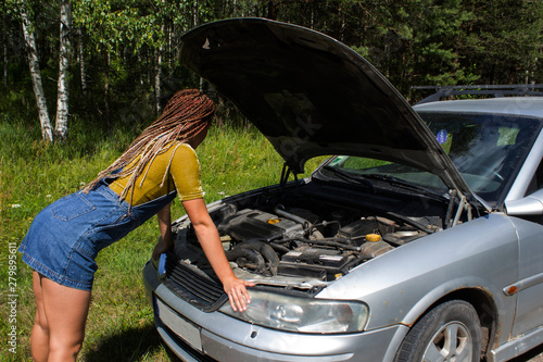 young girl with an open hood at the broken machine