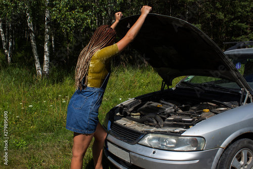 young girl with an open hood at the broken machine