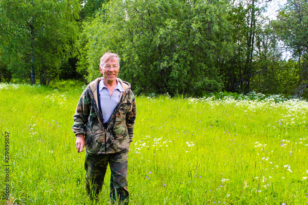 an elderly man in the woods in the meadow in the summer