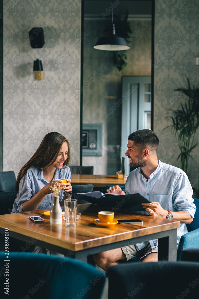 A happy young couple looking at their menu's at a restaurant A happy young couple looking at their menu's at a restaurant