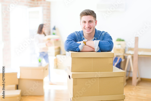 Beautiful young couple moving to a new home, young man smiling happy to the camera excited for new apartment