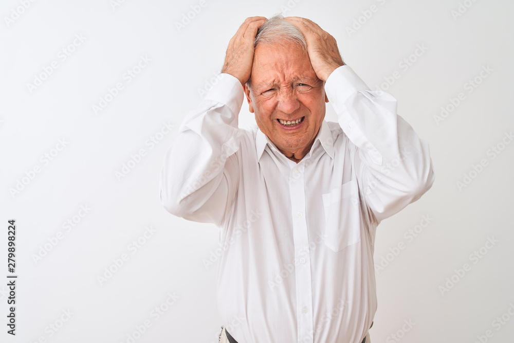 Senior grey-haired man wearing elegant shirt standing over isolated white background suffering from headache desperate and stressed because pain and migraine. Hands on head. Senior grey-haired man wearing elegant shirt standing over isolated white background suffering from headache desperate and stressed because pain and migraine. Hands on head.