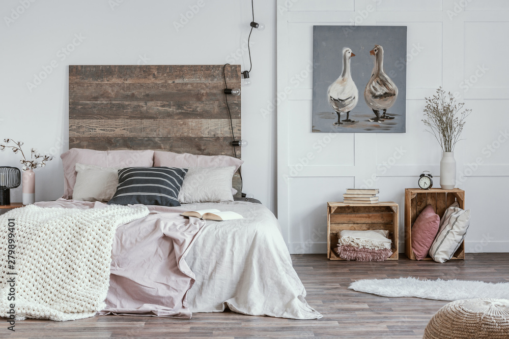 Spacious, feminine bedroom interior with rustic furniture, white walls, wooden crates and oil painting of animals. Real photo - obrazy, fototapety, plakaty 