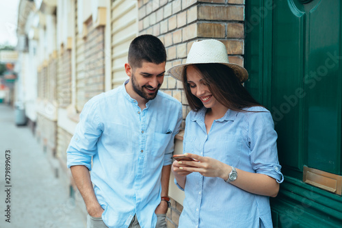 man and woman using cellphone outdoor in the city