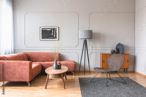 Stylish tall grey lamp in elegant living room interior with comfortable brown corner sofa © Photographee.eu