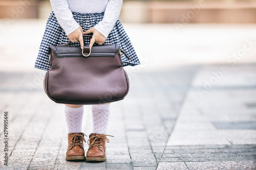 Little girl wearing uniform with a school bag, close up photo, back to school