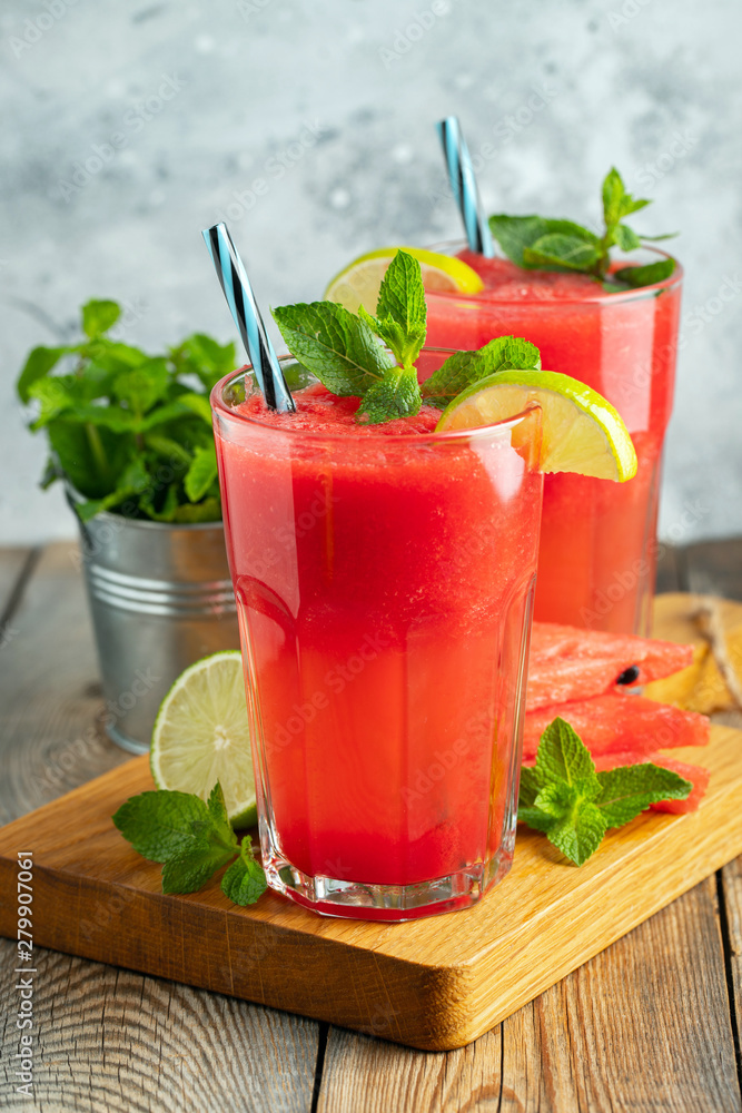 Watermelon slushie with lime and mint, summer refreshing drink in tall glasses on a light blue background. Sweet cold smoothie Watermelon slushie with lime and mint, summer refreshing drink in tall glasses on a light blue background. Sweet cold smoothie