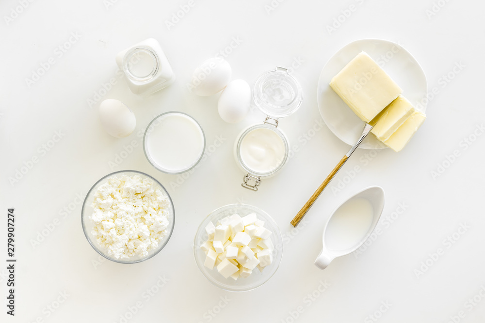 Fototapeta premium Fresh dairy products for breakfast with milk, cottage, eggs, butter, yougurt on white background top view