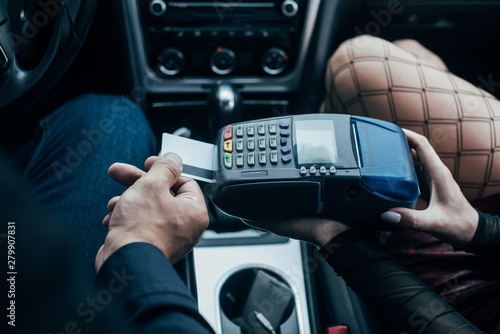 top view of client paying by credit card near prostitute in car
