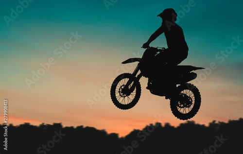 Motocross Dirt Bike rider getting air off of jump at sunset © Christian