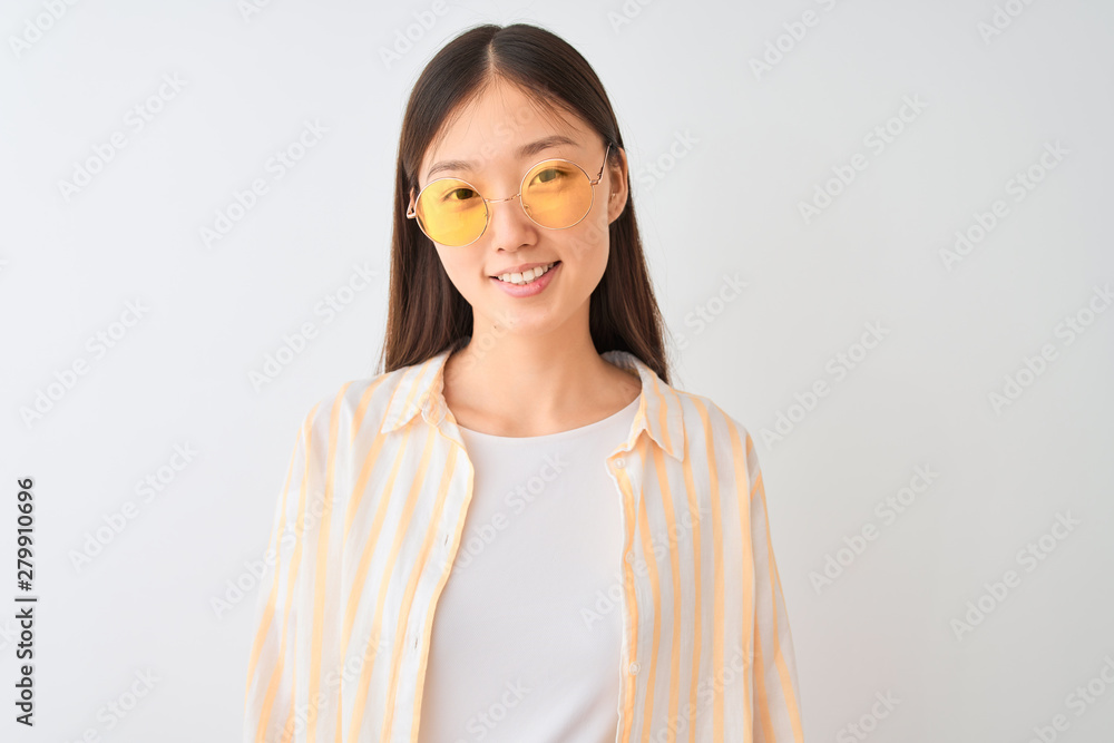Young chinese woman wearing striped shirt and glasses over isolated white background with a happy face standing and smiling with a confident smile showing teeth Young chinese woman wearing striped shirt and glasses over isolated white background with a happy face standing and smiling with a confident smile showing teeth