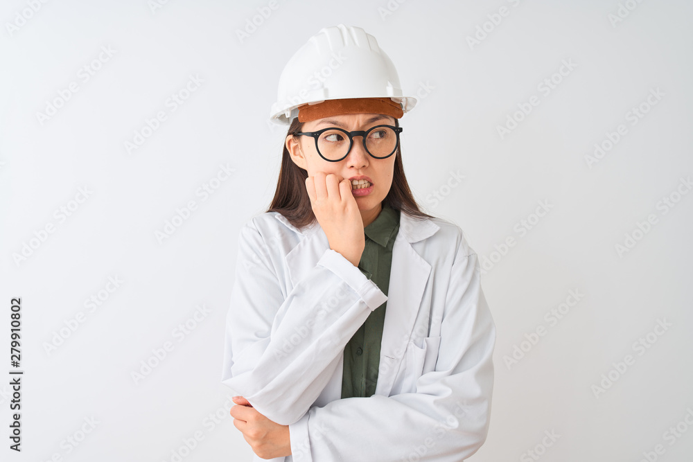 Young chinese engineer woman wearing coat helmet glasses over isolated white background looking stressed and nervous with hands on mouth biting nails. Anxiety problem. Young chinese engineer woman wearing coat helmet glasses over isolated white background looking stressed and nervous with hands on mouth biting nails. Anxiety problem.