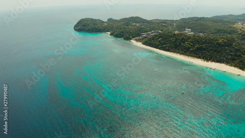 Sandy beach and turquoise water in the tropical resort of Boracay, Puka shell beach, Philippines aerial view. White beach with tourists. Summer and travel vacation concept.