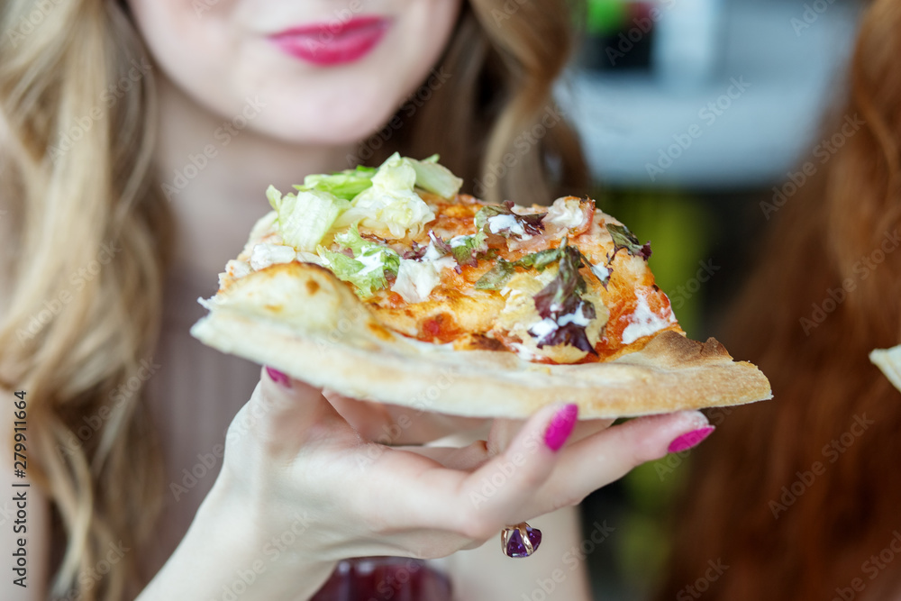 Woman eats a tasty slice of pizza. Concept of food, fast food Woman eats a tasty slice of pizza. Concept of food, fast food