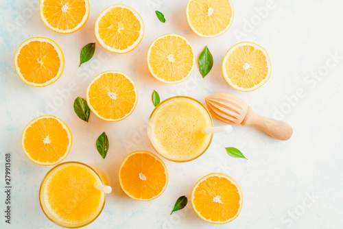 Fresh Orange juice in glass and fresh citrus around. Healthy drink on white. Top view.