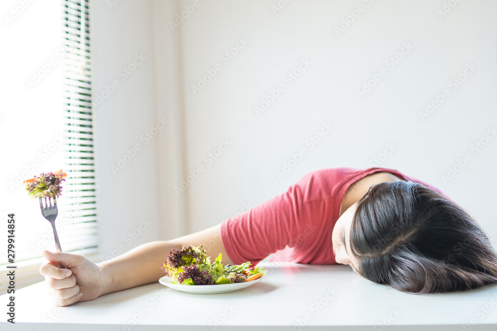 Unhappy woman bored vegetable, girl is on diet and laying down and ...